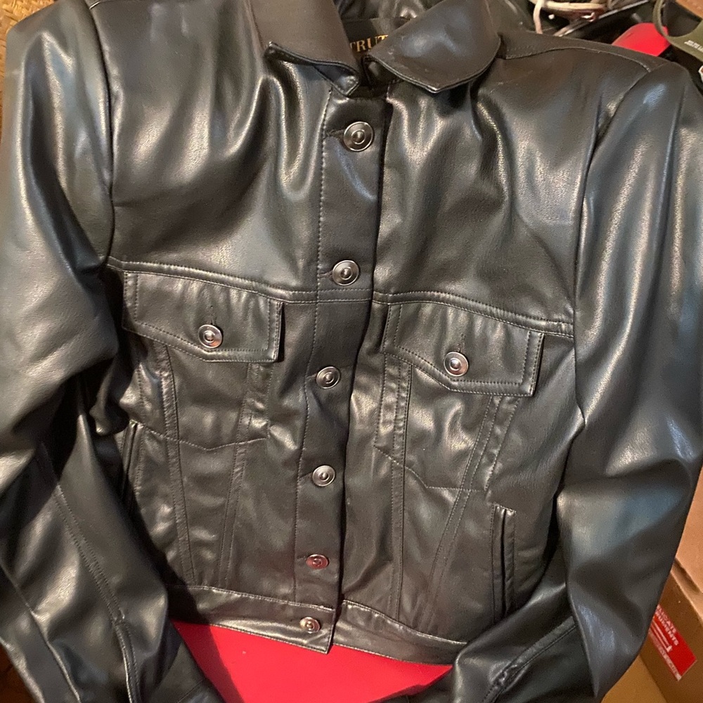 Collared Long sleeve. Front chest pockets and bottom cuff. Faux leather fabric.